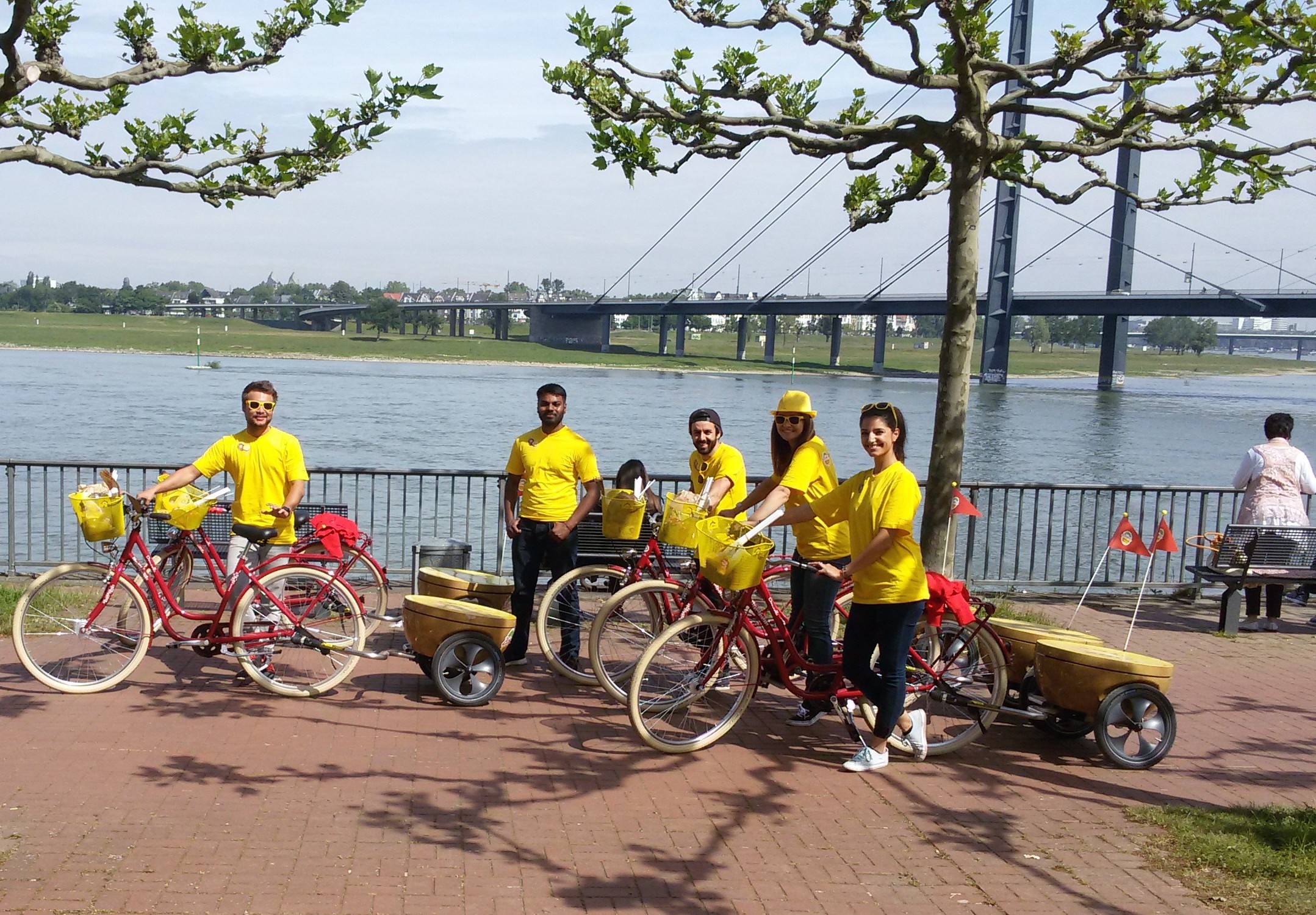 Promoter/innen mit Fahrrädern mit Anhänger in Kiwiform am Rhein in Düsseldorf