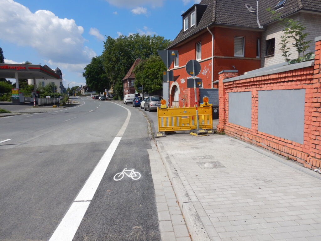 Radfahrstreifen, im Vordergrund neu markiert, im Hintergrund mit ausgeblichener Markierung